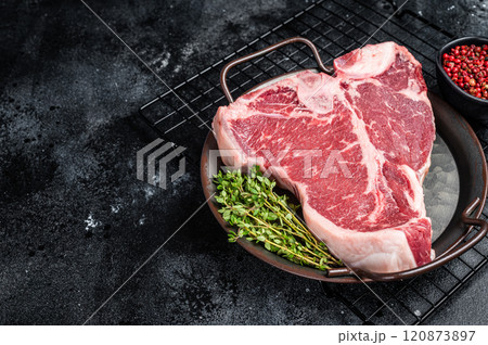 Fresh raw T-bone marbled beef meat Steak on a steel tray. Black background. Top view. Copy space 120873897