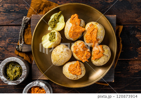 Canary Islands dish Papas Arrugadas wrinkly salty potatoes with and Mojo picon red spicy sauce. Wooden background. Top view 120873914