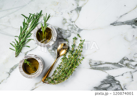 Flavoring: extra virgin olive oil with thyme and rosemary. Top view. White background. Copy space Flavoring: extra virgin olive oil with thyme and rosemary. Top view. White background. Copy space 120874001