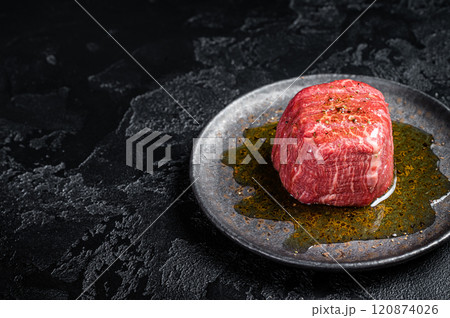 Fillet Mignon prime beef steak, raw dry aged marble meat with herbs and spices ready for cooking. Black background. Top view. Space for text Fillet Mignon prime beef steak, raw dry aged marble meat with herbs and spices ready for cooking. Black background. Top view. Space for text 120874026