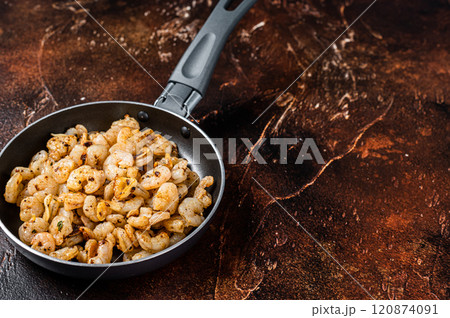 Fried peeled Shrimps prawns with garlic, olive oil in a skillet. Dark background. top view. copy space 120874091