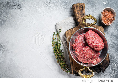 Raw Hamburger patty, groud beef Meat, uncooked meat cutlets. White background. Top view. Space for text Raw Hamburger patty, groud beef Meat, uncooked meat cutlets. White background. Top view. Space for text 120874101