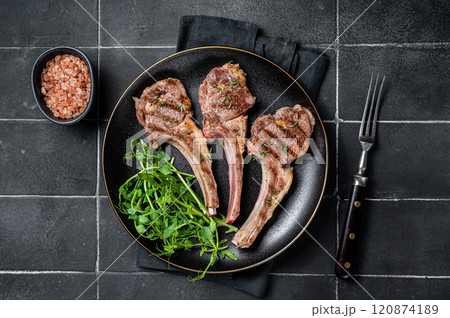 Roasted lamb meat cutlets, mutton chops with garnish. Black background. Top view 120874189