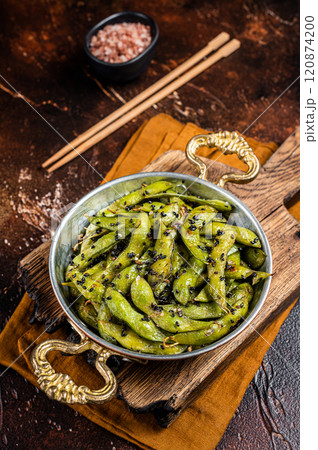 Roasted green Edamame Soy Beans with sea salt and sesame seeds in a skillet. Dark background. Top view 120874200
