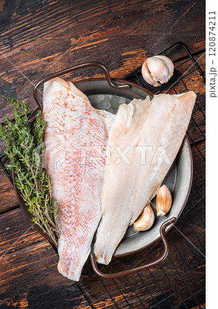 Raw red perch fillet, redfish fish meat in a steel tray. Wooden background. Top view Raw red perch fillet, redfish fish meat in a steel tray. Wooden background. Top view 120874211