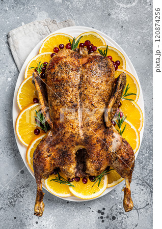 Christmas roast duck with apples and oranges, festive christmas recipe. Gray background. Top view 120874256