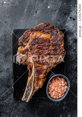 Grilled cowboy or rib eye with bone beef steak. Black background. Top view Grilled cowboy or rib eye with bone beef steak. Black background. Top view 120874260