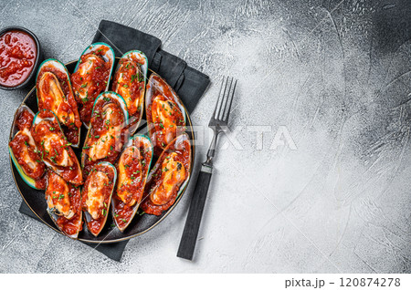 Large green mussels cooked in tomato sauce with garlic, parsley and lemon. White background. Top view. Copy space Large green mussels cooked in tomato sauce with garlic, parsley and lemon. White background. Top view. Copy space 120874278