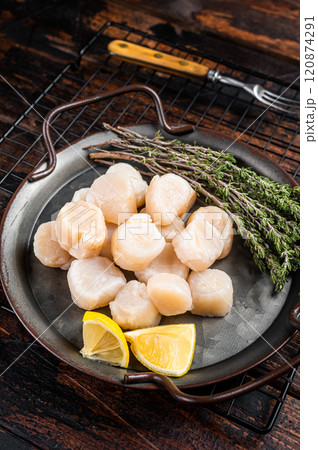Raw scallops in a steel tray with herbs. Wooden background. Top view 120874291