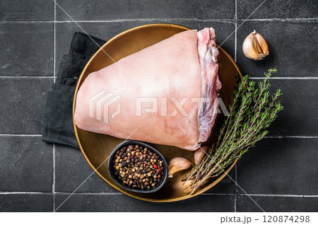 Raw pork ham hocks on a steel plate with herbs. Black background. Top view Raw pork ham hocks on a steel plate with herbs. Black background. Top view 120874298