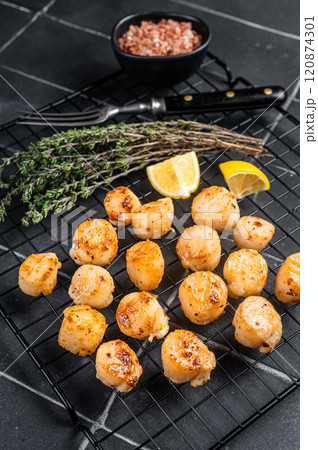 Grilled Scallops fillets on a rack. Black background. Top view 120874301
