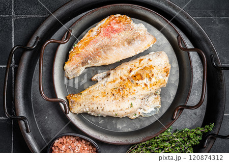 Roasted ocean red perch fillet with olive oil, thyme and spices. Black background. Top view 120874312