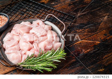 Diced raw chicken breast fillets with herbs, fowl meat. Wooden background. Top view. Copy space 120874315