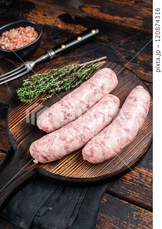 Fresh Raw Bratwurst meat sausages ready for cooking on wooden board. Wooden background. Top view 120874316