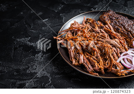 BBQ pulled pork meat on plate. Black background. Top view. Copy space BBQ pulled pork meat on plate. Black background. Top view. Copy space 120874323
