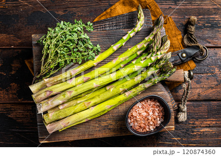 Bunch of Raw green asparagus on a wooden cutting board. Wooden background. Top view Bunch of Raw green asparagus on a wooden cutting board. Wooden background. Top view 120874360