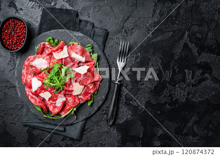 Beef carpaccio with arugula, parmesan cheese. Black background. Top view. Copy space Beef carpaccio with arugula, parmesan cheese. Black background. Top view. Copy space 120874372