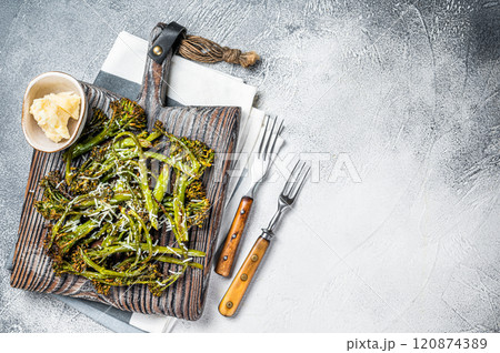Baked Broccolini cabbage Sprouts with parmesan cheese on wooden board. White background. Top view. Copy space 120874389