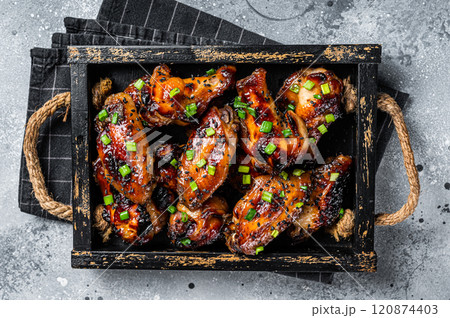 BBQ Chicken wings in Teriyaki sauce with black sesame in a tray. Gray background. Top view 120874403
