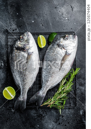 Raw sea bream dorado fish ready for cooking. Black background. Top view Raw sea bream dorado fish ready for cooking. Black background. Top view 120874404