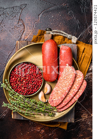 Sliced halal Sucuk beef meat sausage. Dark background. Top view Sliced halal Sucuk beef meat sausage. Dark background. Top view 120874421