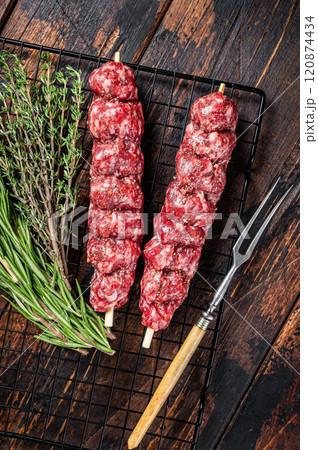 Raw kofta, kofte kebab Skewers with beef and lamb meat and spices ready for cooking. Wooden background. Top view Raw kofta, kofte kebab Skewers with beef and lamb meat and spices ready for cooking. Wooden background. Top view 120874434