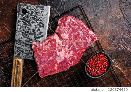 Raw skirt beef steak on meat cleaver. Black background. Top view 120874439