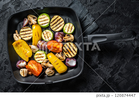 Vegetables grilled in a grill skillet, bell pepper, zucchini, eggplant, onion and tomato. Black background. Top view Vegetables grilled in a grill skillet, bell pepper, zucchini, eggplant, onion and tomato. Black background. Top view 120874447