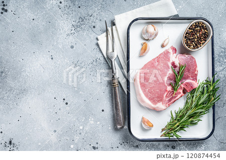 Ready for cooking Raw pork t-bone chop meat steak with herbs and spices. Gray background. Top view. Copy space Ready for cooking Raw pork t-bone chop meat steak with herbs and spices. Gray background. Top view. Copy space 120874454