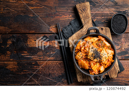 Kimchi salted and fermented chinese cabbage in a skillet. Wooden background. Top view. Copy space Kimchi salted and fermented chinese cabbage in a skillet. Wooden background. Top view. Copy space 120874492