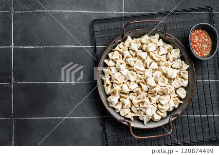 Cooking Manti Dumpling, raw food in a steel tray. Black background. Top view. Copy space 120874499
