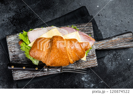 Croissant Club Sandwich with Ham and Cheese, cup of coffe. Black background. Top view 120874522