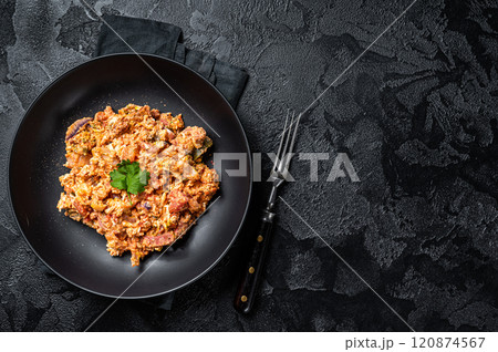 Turkish Menemen, Eggs with tomatoes, green peppers and green onion. Black background. Top view. Copy space 120874567
