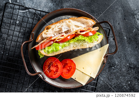 Deli meat sandwich with turkey ham, cheese, tomato and Lettuce. Black background. Top view Deli meat sandwich with turkey ham, cheese, tomato and Lettuce. Black background. Top view 120874592