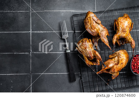 Grilled whole quails with herbs and spices. Black background. Top view. Copy space Grilled whole quails with herbs and spices. Black background. Top view. Copy space 120874600