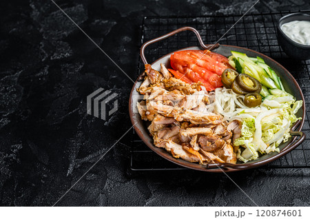 Doner kebab or gyros on a plate with french fries, vegetables and salad. Black background. Top view. Copy space Doner kebab or gyros on a plate with french fries, vegetables and salad. Black background. Top view. Copy space 120874601