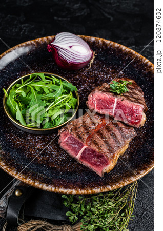 Grilled Oyster Top Blade beef meat steak on a plate with salad. Black background. Top View Grilled Oyster Top Blade beef meat steak on a plate with salad. Black background. Top View 120874632