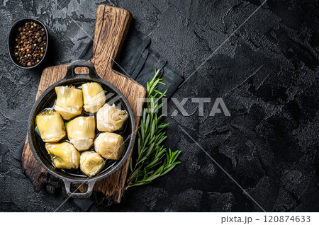 Artichoke hearts pickled in olive oil with herbs and spices Black background. Top view. Copy space 120874633