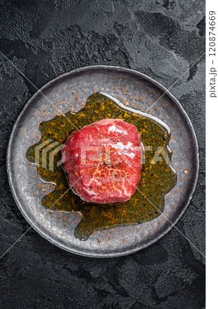 Fillet Mignon prime beef steak, raw dry aged marble meat with herbs and spices ready for cooking. Black background. Top view 120874669
