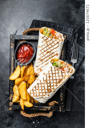 Durum doner kebab or Shawarma with meat, vegetable salad and french fries. Black background. Top view 120874671