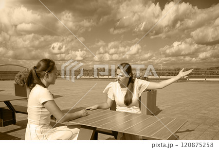 Girls arguing in a cafe Girls arguing in a cafe 120875258