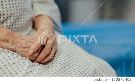 Hands of old woman with serious health issues sitting on hospital bed. Elderly patient feeling pain. Hands of old woman with serious health issues sitting on hospital bed. Elderly patient feeling pain. 120875402