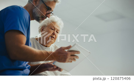 Hospital doctor delivering bed news to old patient, cosulting with her. Old patient with serious health issues suffering from pain. 120875406