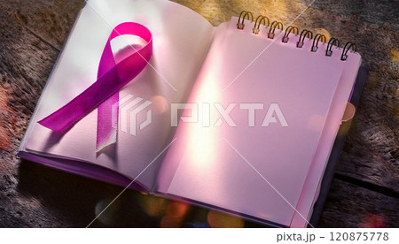 A pink ribbon is on a notebook 120875778