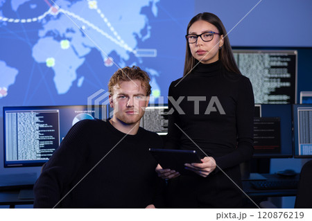 Professional serious cyber security team in front of cybersecurity SIEM system with logs and incident map 120876219