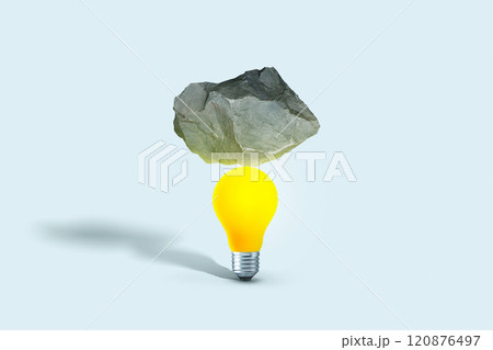 Stone put on yellow light bulb floating on blue background. minimal creative idea concept. Balance, creative idea. Startup, concept 120876497
