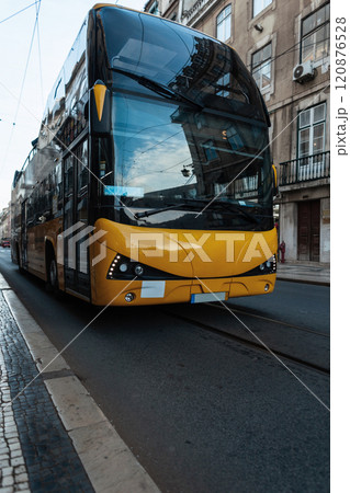 Big yellow bus rides in the city with Lisbon, Portugal. Travel and Holidays 120876528