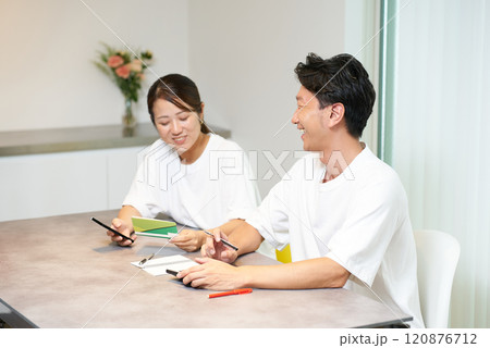 銀行口座の通帳を見る男女 120876712