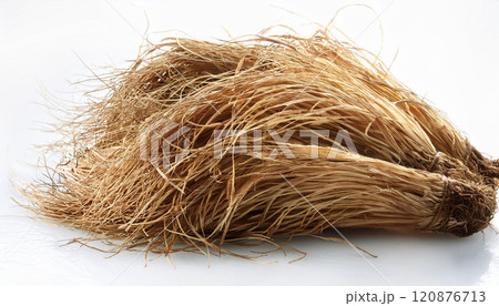 A bunch of dry, brown straw is laying on a white surface A bunch of dry, brown straw is laying on a white surface 120876713