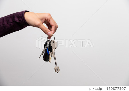 Woman's hand holding a house key 120877307